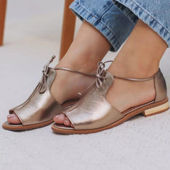 Champagne metallic leather open-toe sandals with lace-up ankle strap, flat sole