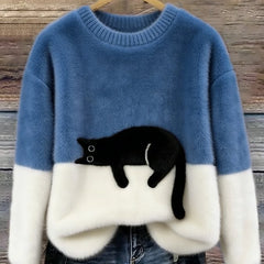 Blue oversized fuzzy sweater with black-and-white penguin applique and white hem detail