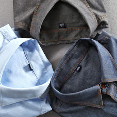 Button-front shirt collars and chest pockets, light blue and charcoal close-up