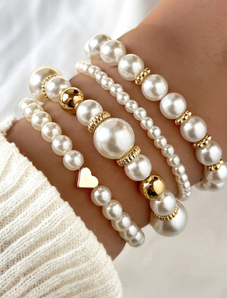 Pearl heart bracelet set on wrist with white pearls and gold round heart details