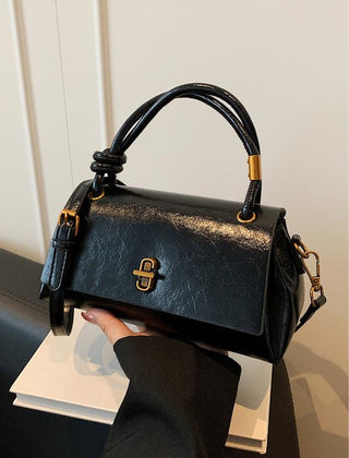 Black leather-look crossbody shoulder bag with gold-tone clasp and top flap