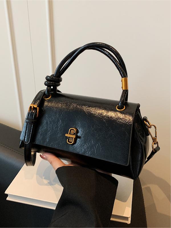 Black leather-look crossbody shoulder bag with gold-tone clasp and top flap