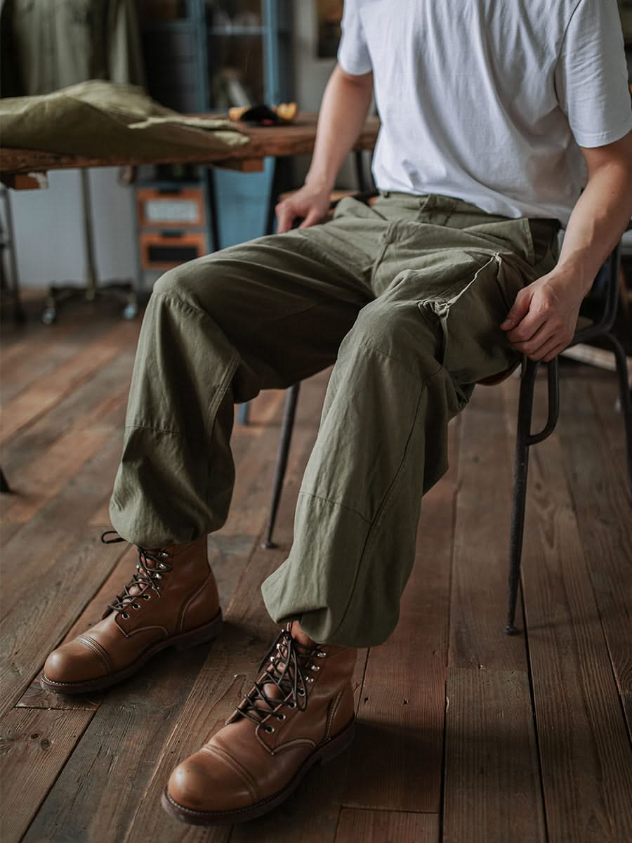 Army green cargo trousers with side pocket flaps and full-length relaxed legs