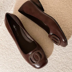 Brown leather flats with oval buckle hardware, top view