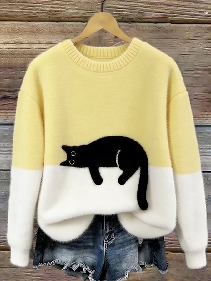 Yellow oversized fuzzy sweater with black-and-white penguin applique and white hem detail