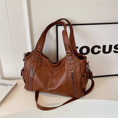 RAE Classic leather handbag, brown leather with top handles, front zippers, and long crossbody strap