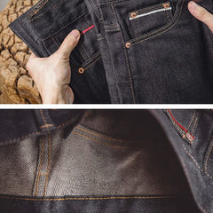 Indigo denim jeans with front pocket, visible lining, and contrast orange topstitching