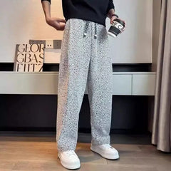 Light grey textured tapered pants with elastic waistband and drawstring ties