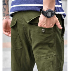 Olive green straight fatigue pants with large front cargo pockets and button waist closure