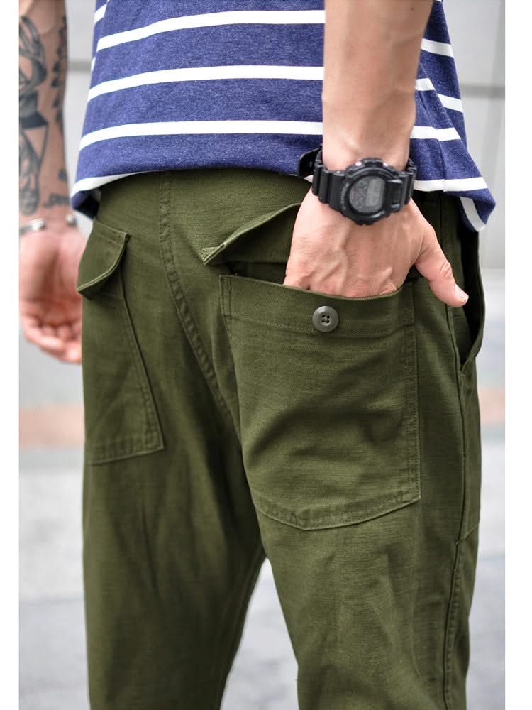 Olive green straight fatigue pants with large front cargo pockets and button waist closure