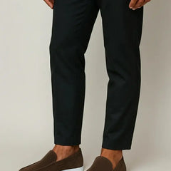 Brown slip-on suede loafer worn with dark trousers