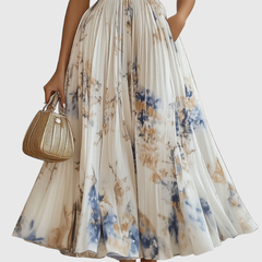 Cream pleated maxi dress with V-neck wrap bodice, blue-and-gold floral skirt, sleeveless.