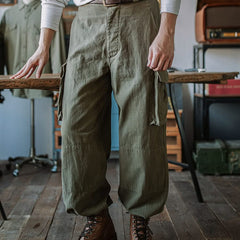 Army green cargo trousers with belt loops, side cargo pocket flaps, drawstring waist