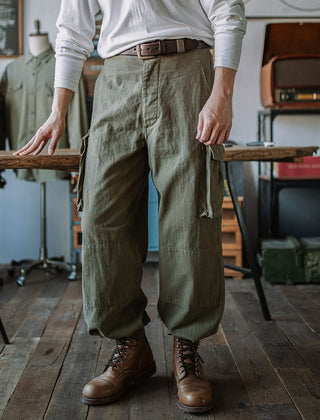Army green cargo trousers with belt loops, side cargo pocket flaps, drawstring waist