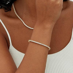Gold-tone tennis bracelet with round stones on wrist