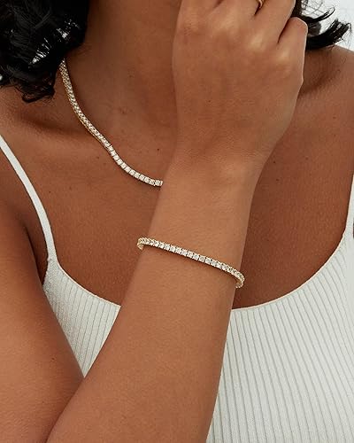 Gold-tone tennis bracelet with round stones on wrist