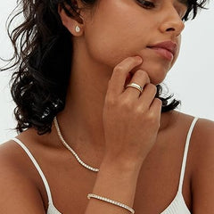 Gold-tone tennis bracelet with round stones on arm
