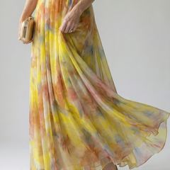 Yellow multicolor maxi wrap dress with flowing skirt and V-neck wrap bodice detail.