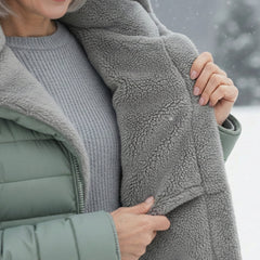 Close-up of gray fleece lining inside a light green puffer coat