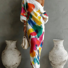 One-shoulder maxi dress in white with bold multicolor abstract paint pattern, draped sleeves