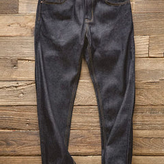 Indigo denim jeans on wood floor, dark wash with button fly and stitched pockets