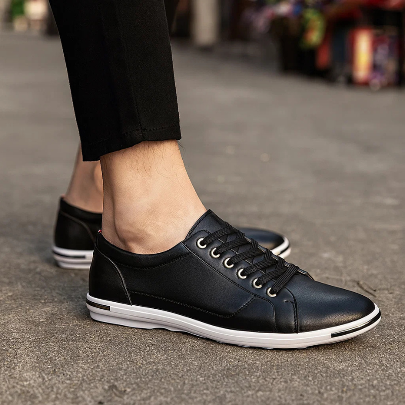Black leather low-top sneaker with lace-up front and white rubber sole