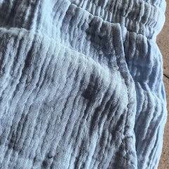 Blue linen-look shorts close-up showing elastic waistband and textured fabric