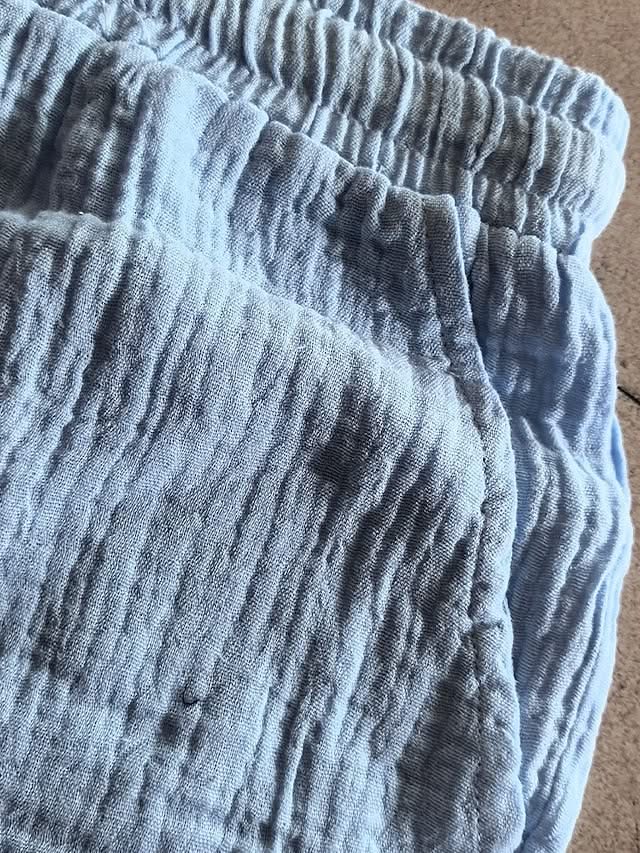 Blue linen-look shorts close-up showing elastic waistband and textured fabric