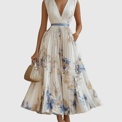 White pleated maxi dress with V-neck, floral print and gathered waist, sleeveless.