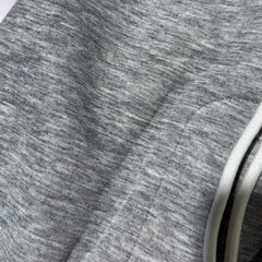Heather grey trouser fabric detail with stitched hem and drawstring cord