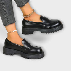 Zelvana black moccasin platform loafers with gold chain ankle strap and white bracelet
