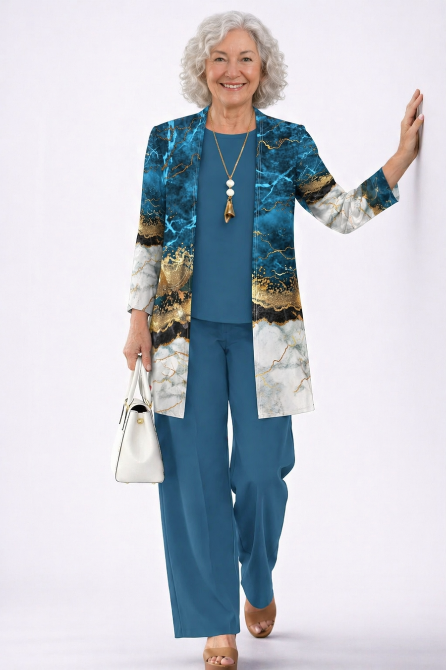 Blue and gold marble duster over teal top and pants, with gold pendant necklace