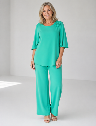 Teal two-piece top and wide-leg pants set with ruffle shoulder detail