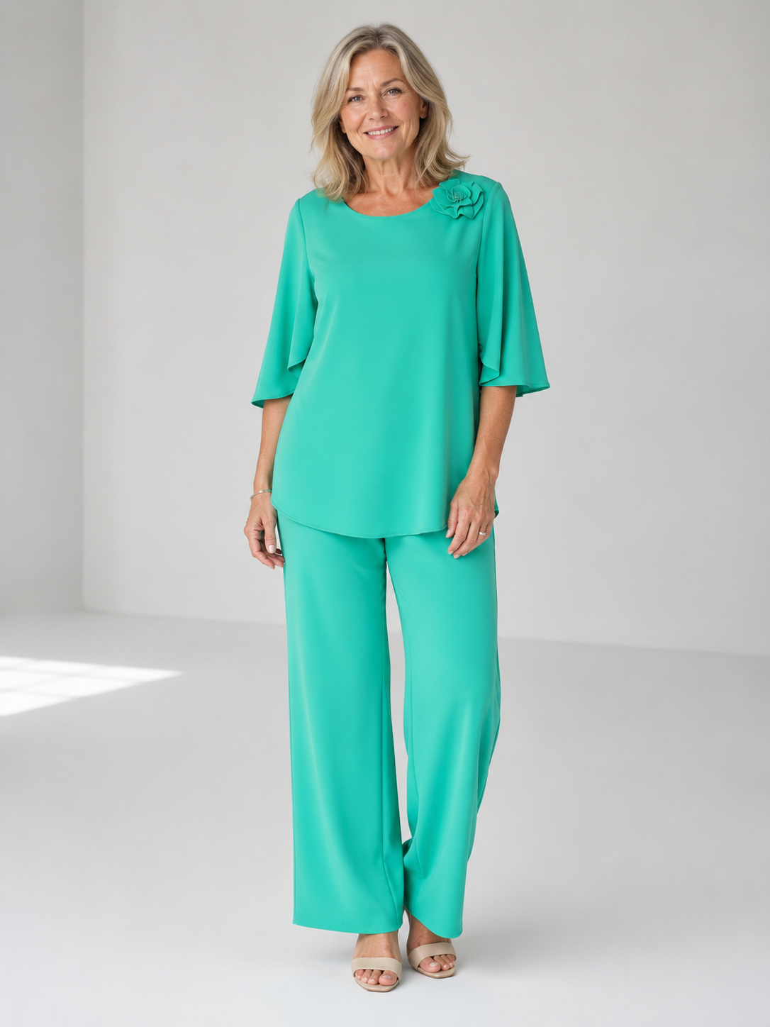 Teal two-piece top and wide-leg pants set with ruffle shoulder detail