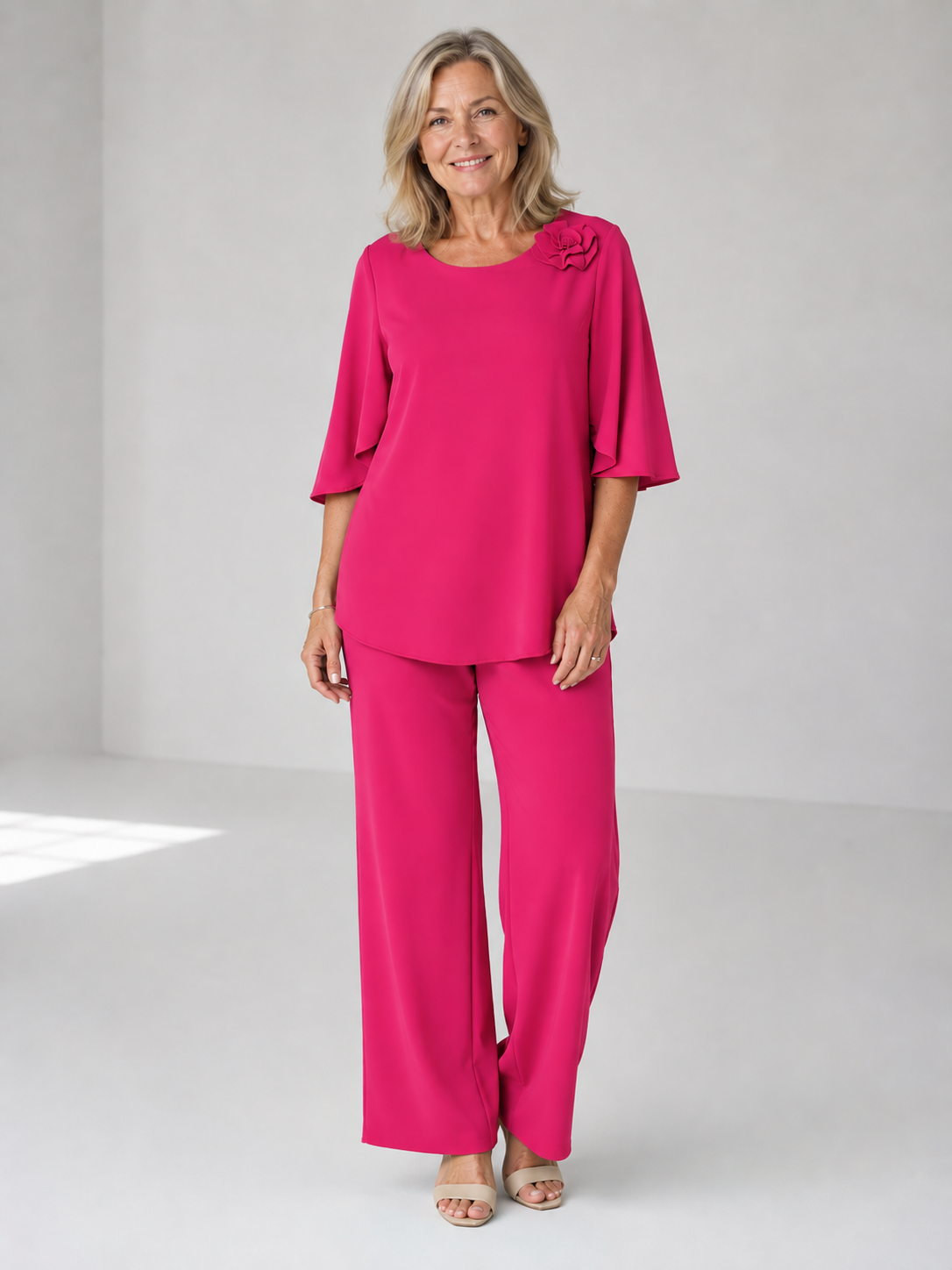 Pink two-piece top and wide-leg pants set with ruffle shoulder detail
