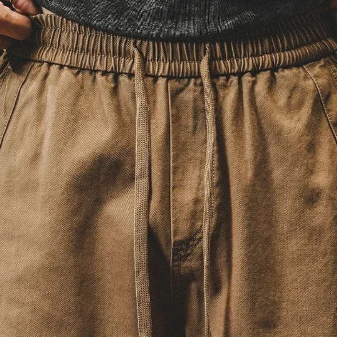 Close-up of tan cargo pants waistband with elastic drawstring