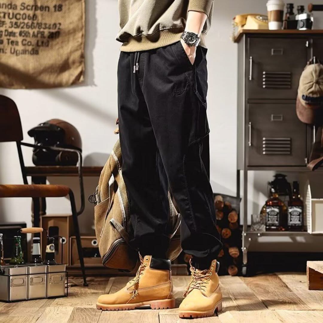 Black cargo pants with cargo pockets and elastic waistband, full-length