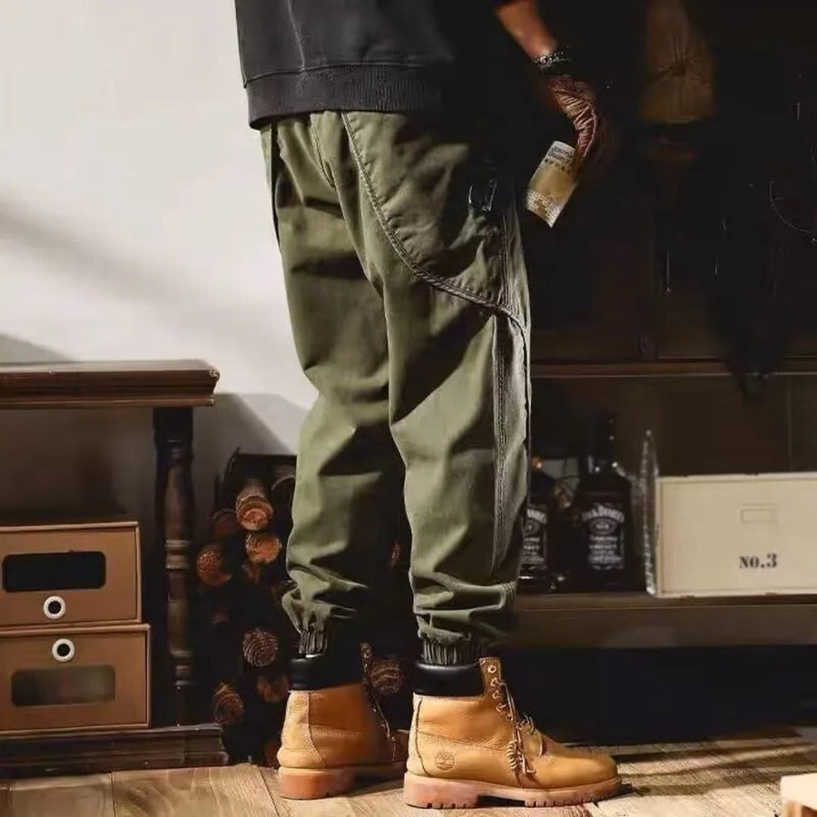 Olive green cargo pants with side pocket and cuffed hem, standing full-length