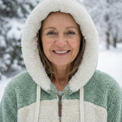 Close-up of plush hooded colorblock jacket in sage green and cream with zip front