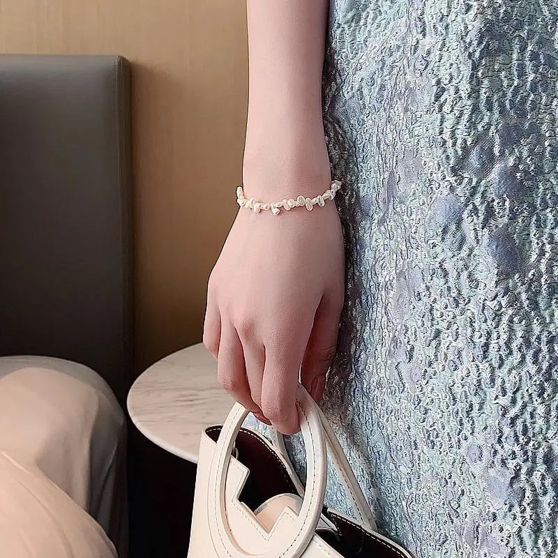 Pearl bracelet with gold-tone chain on wrist
