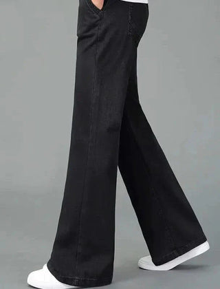 Black flare boot cut jeans shown in motion, wide leg with stitched front pockets