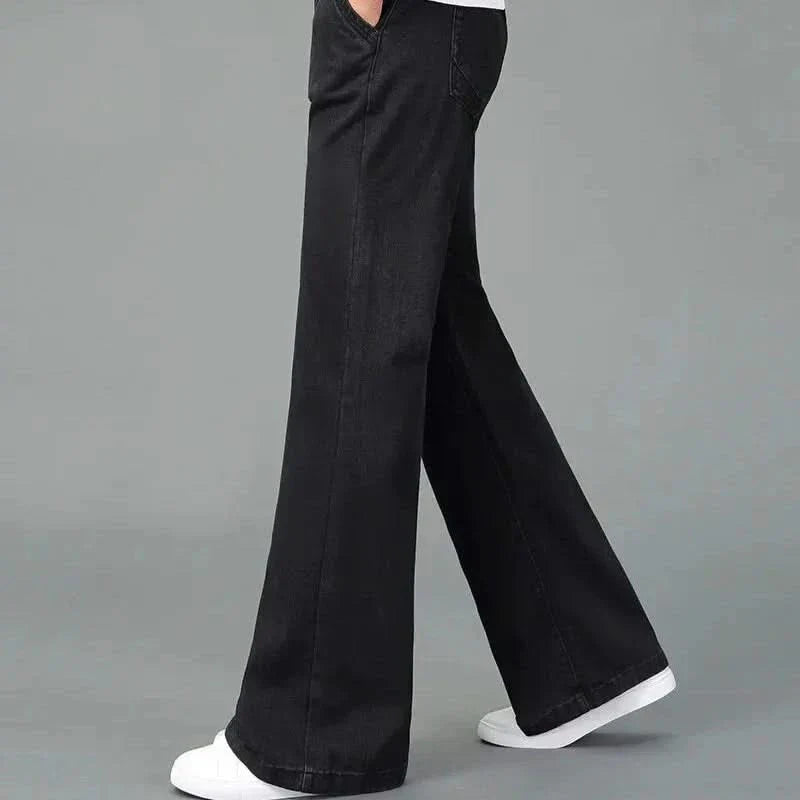 Black flare boot cut jeans shown in motion, wide leg with stitched front pockets