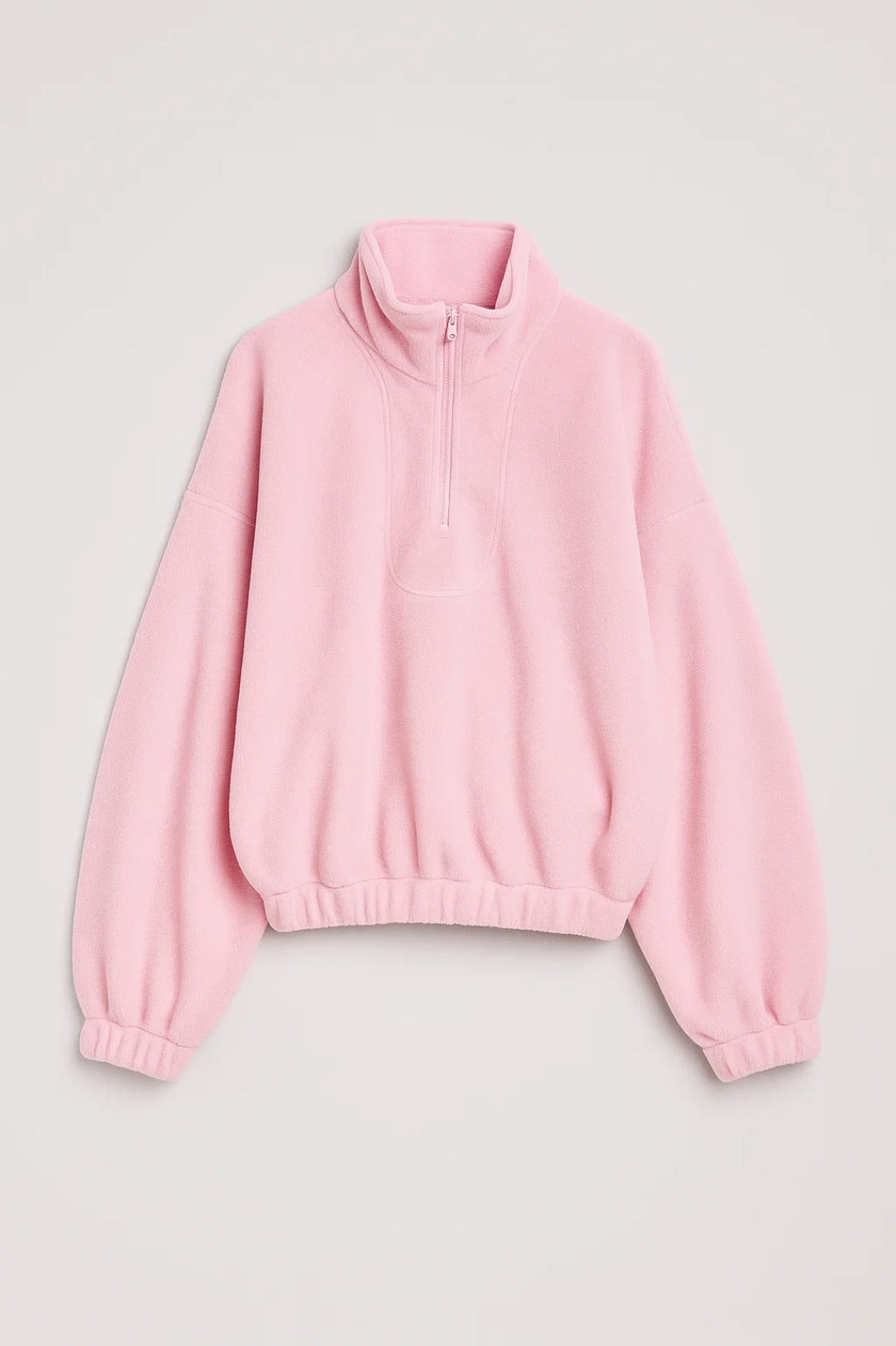 Light pink knit half-zip sweater with stand collar, dropped shoulders, ribbed hem