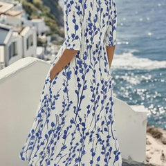 Women’s white midi dress with blue botanical print, standing side view, midi length