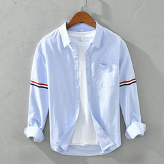Light blue linen shirt with button front, chest pocket, and striped sleeve cuffs
