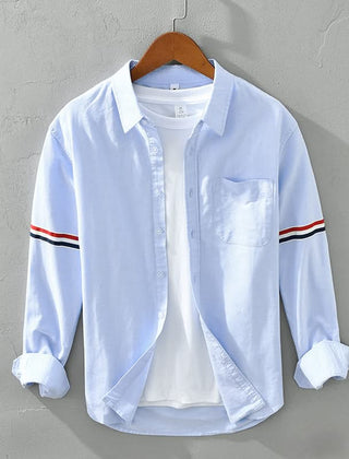 Light blue linen shirt with button front, chest pocket, and striped sleeve cuffs