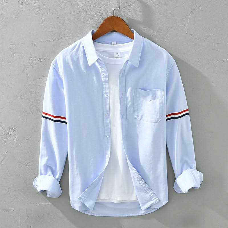 Light blue linen shirt with button front, chest pocket, and striped sleeve cuffs