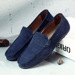 Suede loafers in navy with strap detailing, moc stitching, and dark rubber sole