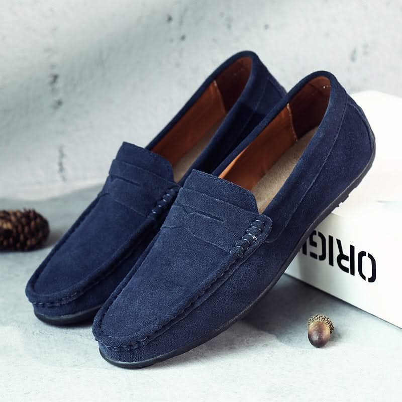 Suede loafers in navy with strap detailing, moc stitching, and dark rubber sole