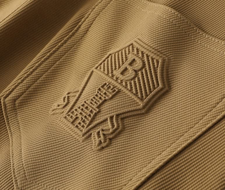 Khaki premium pants fabric close-up with embossed back pocket logo
